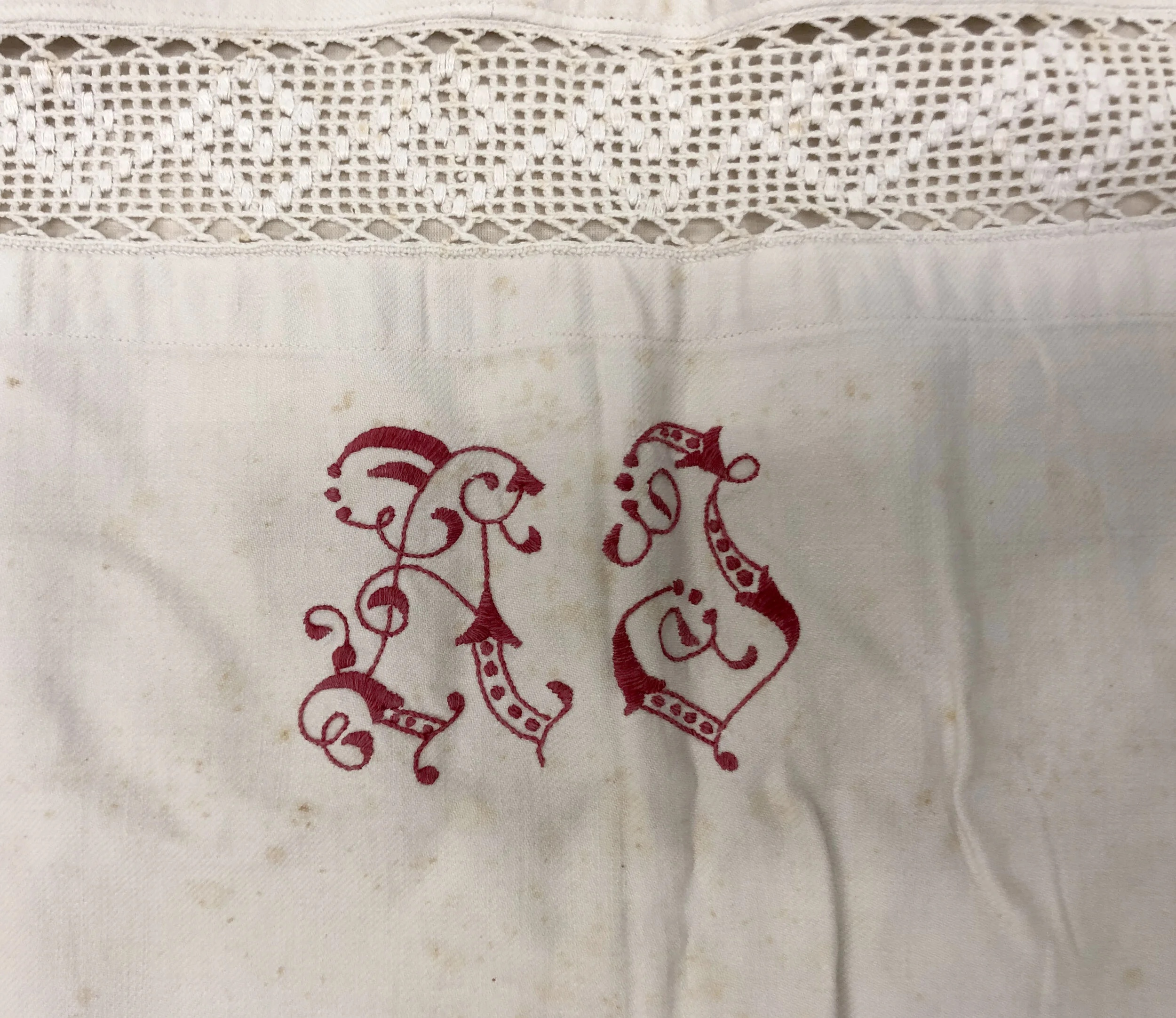 Linen sheet and its embroidered detail (initials AL) underneath the crochet border